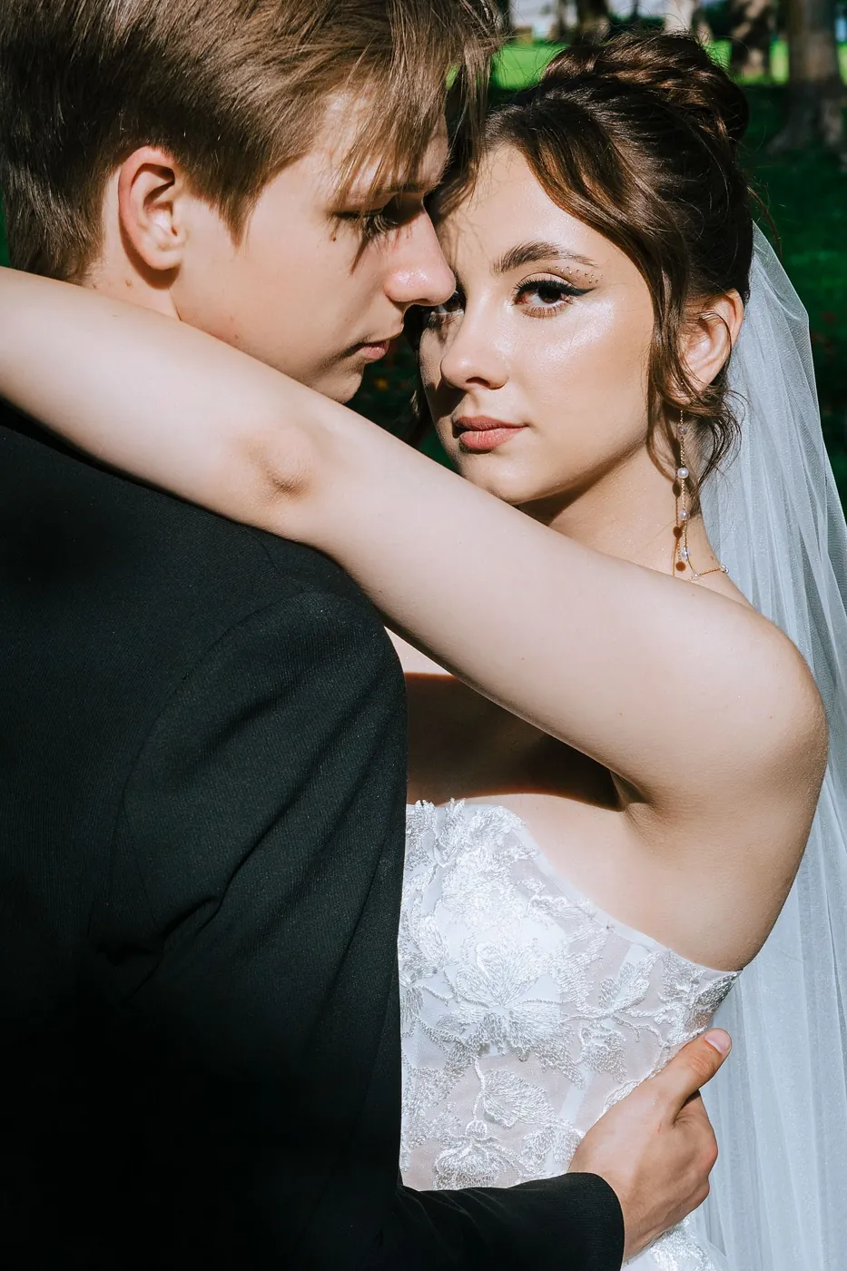 A bride and groom embracing in a close wedding portrait