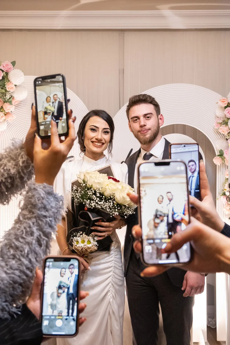 Guests taking phone photos of the newlyweds