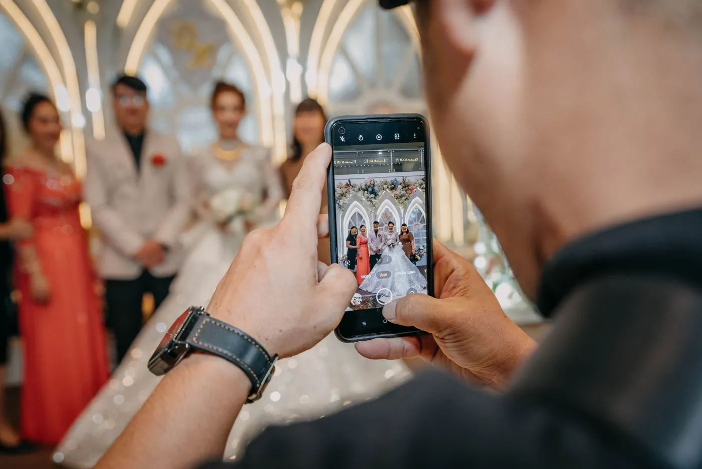 A guest photographing the ceremony on a phone